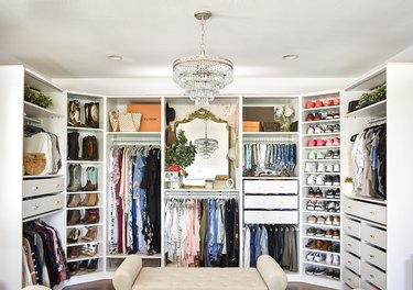 large walk-in closet with glass chandelier