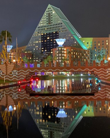 The Walt Disney World Swan and Dolphin Resort triangular building lit up at night.