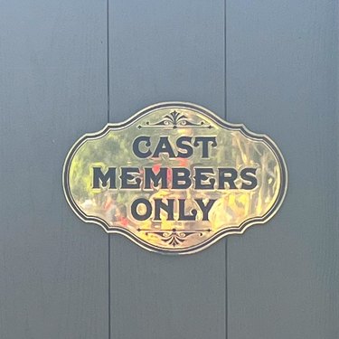 A "cast members only" sign on black vertical wood planks at Disney World's Magic Kingdom.