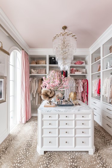 pink and white dressing room with white island dresser