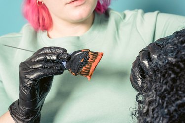 woman with pink hair dyeing black hair orange