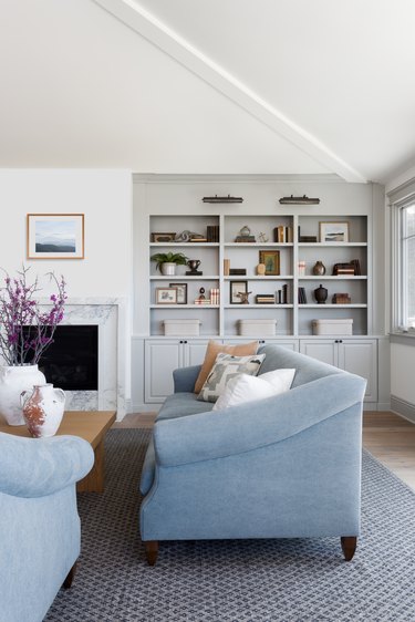 living room with blue couches and built-in shelves