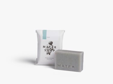 A gray-blue bar of soap next to white packaging that says "Mater Soap."