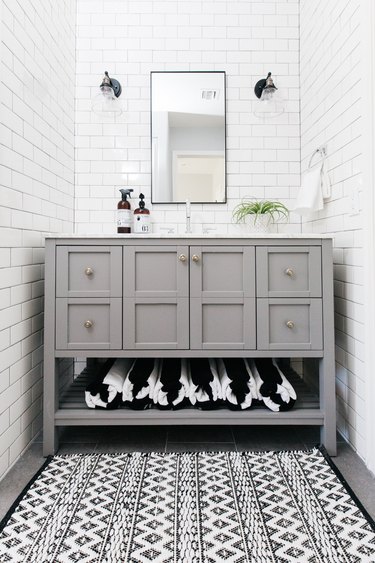 gray cabinet in white subway tile bathroom