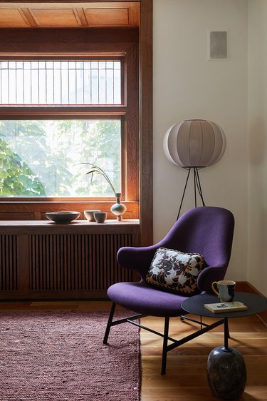 Living room with purple chair, burgundy rug.