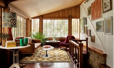 corner sitting room with knotty pine walls, and doses of pattern
