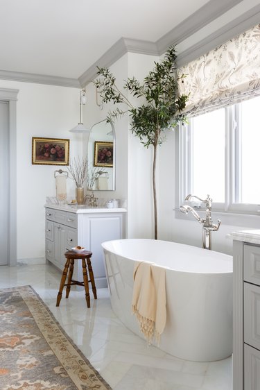 bathroom with white tub and windows nearby
