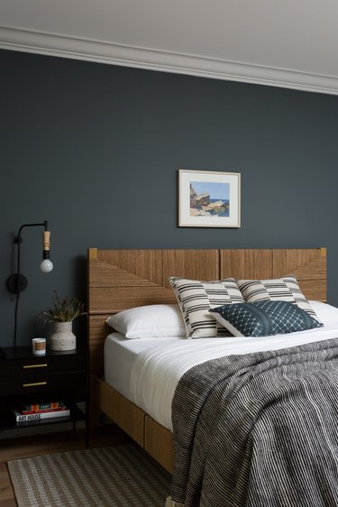 guest room with dark blue wall and wood bed frame