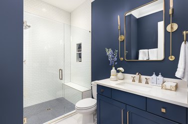 Bathroom with navy walls and gold accents