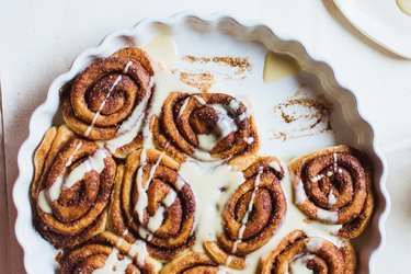 Cinnamon rolls with icing in a white pan
