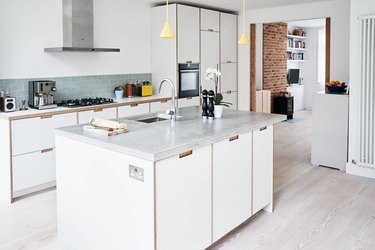 modern kitchen with white cabinets showcasing wood trim