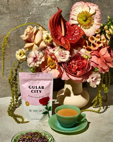 mug with tea and tea packet that read "Gulab City" with flowers nearby