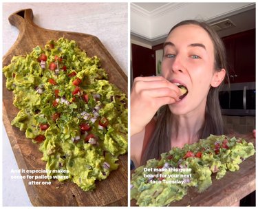On the left is guacamole smeared on a wooden board topped with tomato, onion, and cilantro. On the right is a woman with brown hair holdup up the guacamole board and eating a chip.