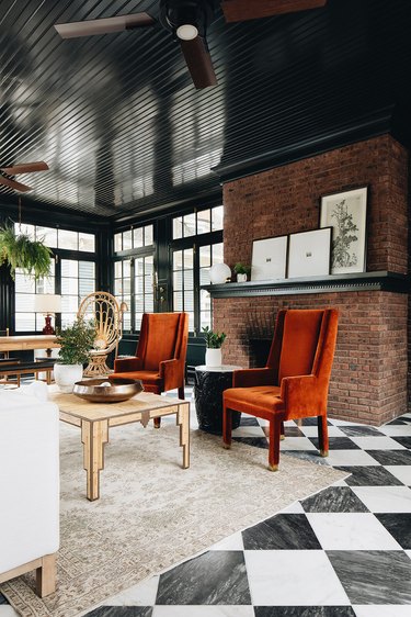 black living room with brick wall and black and white checkerboard floor