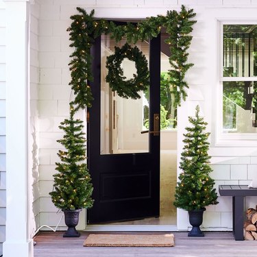 Christmas greenery is on a front porch