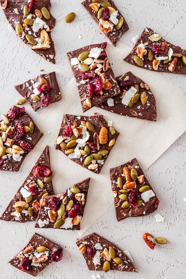 Individual pieces of the broken chocolate bark on parchment paper.