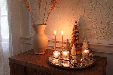 DIY mirrored tray holiday centerpiece with candles lit, bottle brush trees and ornaments