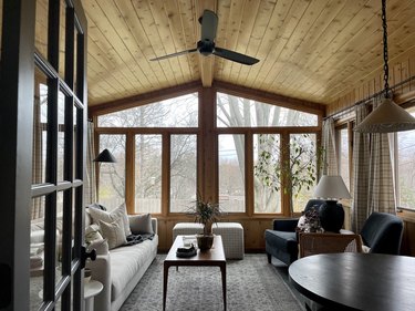 sunroom with knotty pine walls and slim profile furniture