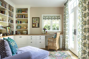 Office with beige walls, green boho print curtains and lavender chaise.