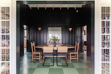 dining room with green floors and black walls