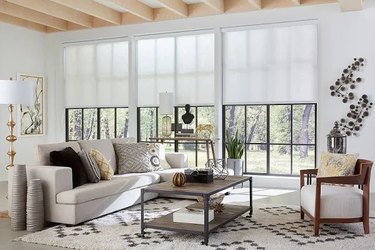 A bright living area with roller shades put halfway down on the windows