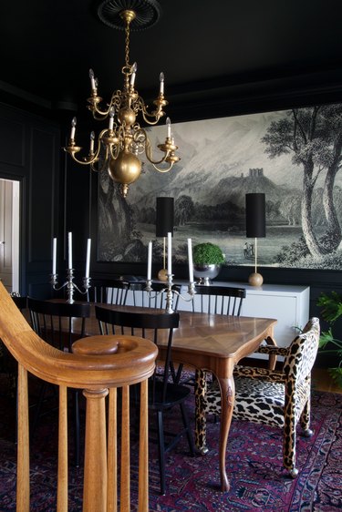 Black dining room with silver candelabras on the table.