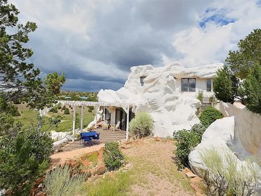 The rock house from the side with a terrace and a view of the Galisteo basin.