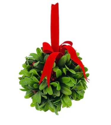 A ball of faux mistletoe, topped with a red ribbon tied in a bow, with extra ribbon at the top.