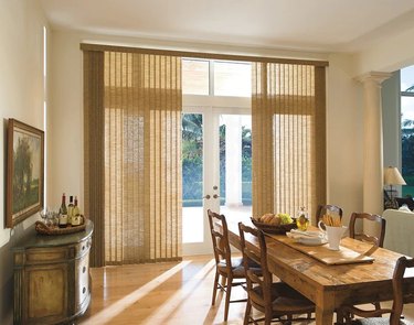 Fabric vertical blinds over a sliding glass door in a dining room