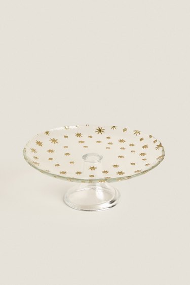 A round case raised cake plate with raised gold stars on it.