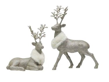 Two silver, glittery decorative stags with white faux fur collars. One is lying down with its head up, and the other is standing.