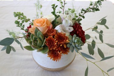 Assorted filler florals added to DIY succulent centerpiece
