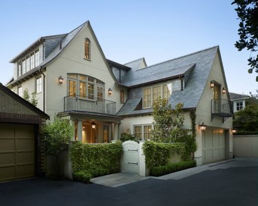 sage green tudor home with gray trim and roof