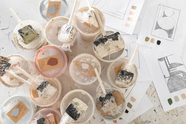 A overhead view of paint cans and paint brushes.