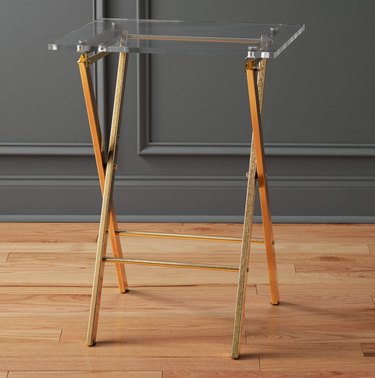Folding acrylic end table with metal legs.