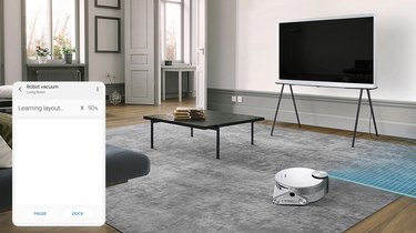 living room with coffee table and tv and white robot vacuum with a screenshot in the left corner