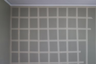 White painter's tape grid on green painted wall