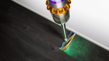 image of dyson v15 with green laser on dark hardwood floor