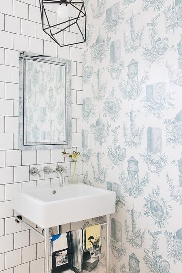 industrial bathroom with wall covered in toile wallpaper
