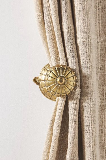 A gold seashell holdback for curtains