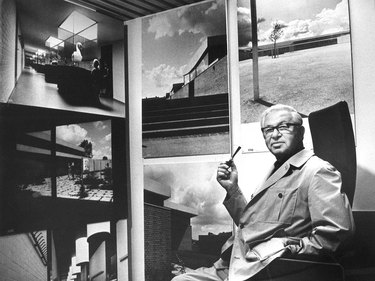 architect arne jacobsen surrounded by photos of his buildings