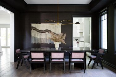 dining room with black walls and wood floors