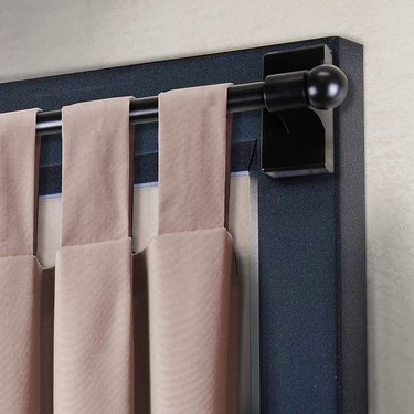 A magnetic curtain rod with a pink curtain hanging
