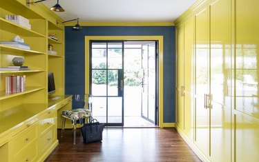 room with dark brown floors and yellow cabinetry
