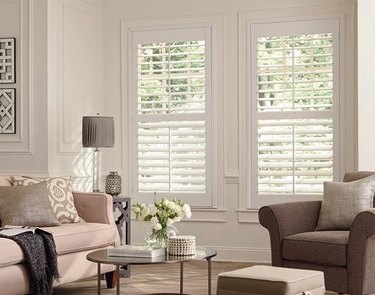 A living room with white louvered interior shutters
