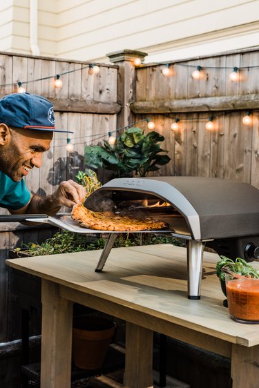 chef douglass williams removing pizza from oven