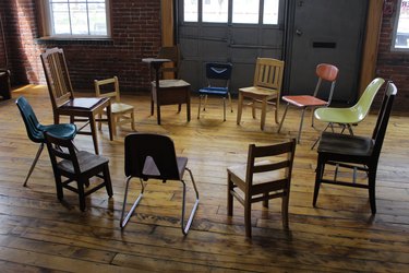 A circle of schoolroom chairs, all taken from different Deaf schools in the region.
