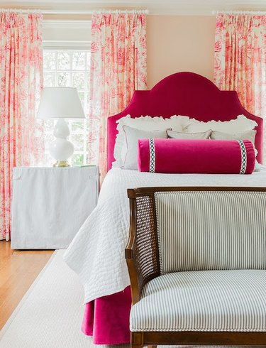 bedroom with fuchsia bed frame and sorbet toile drapes