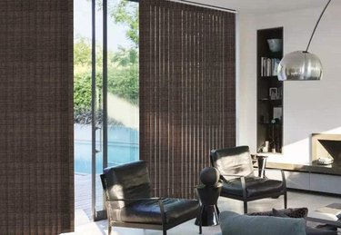Living room with blackout vertical blinds on sliding glass patio doors.