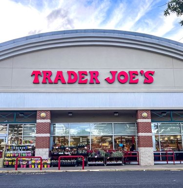 Trader Joe's storefront with logo in front of a blue sky.